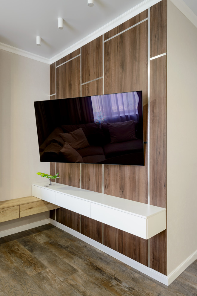 Источник вдохновения для домашнего уюта: большая открытая гостиная комната в современном стиле с бежевыми стенами, полом из винила, телевизором на стене, коричневым полом и тюлем на окнах
