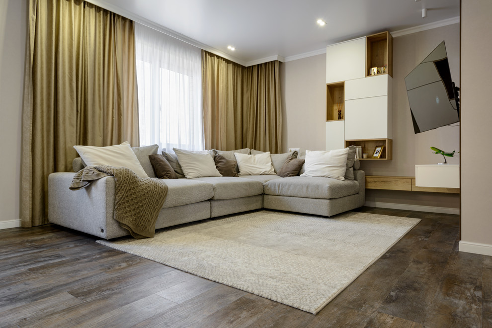 Cette photo montre un grand salon tendance ouvert avec un mur beige, un sol en vinyl, un téléviseur fixé au mur et un sol marron.
