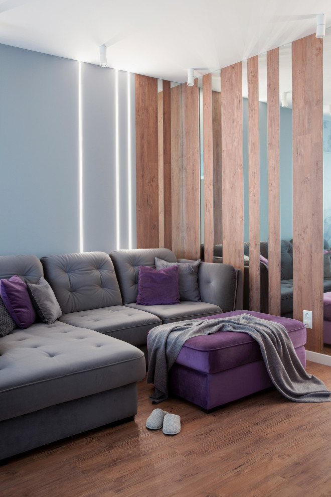 Пример оригинального дизайна: большая открытая гостиная комната в современном стиле с серыми стенами, полом из винила, телевизором на стене, коричневым полом и обоями на стенах