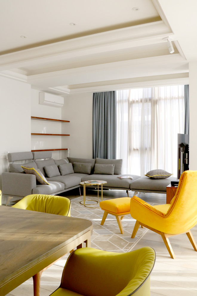 Aménagement d'un salon contemporain ouvert avec un mur blanc, un téléviseur indépendant et un sol beige.