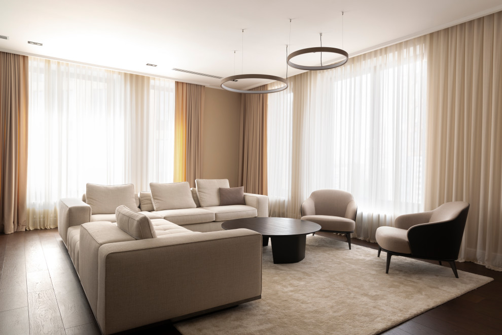 На фото: гостиная комната в стиле модернизм с бежевыми стенами, темным паркетным полом и коричневым полом
