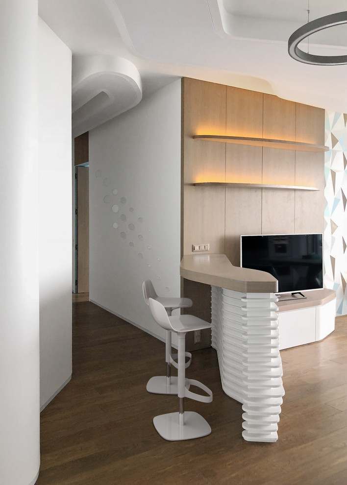 Стильный дизайн: объединенная гостиная комната в современном стиле с белыми стенами, отдельно стоящим телевизором, коричневым полом и многоуровневым потолком - последний тренд