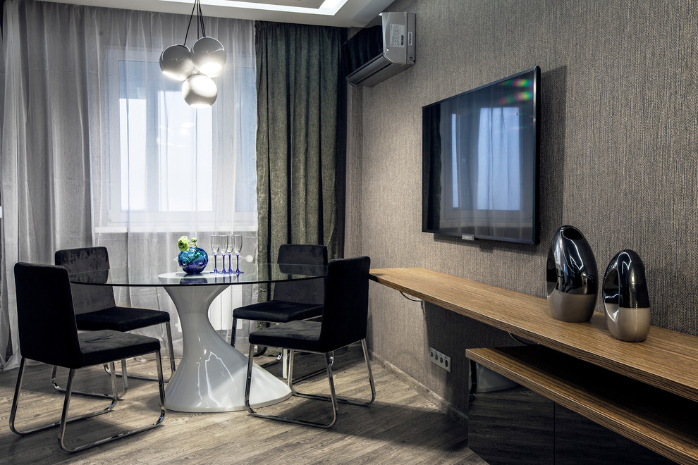 Идея дизайна: большая открытая гостиная комната в современном стиле с паркетным полом среднего тона, телевизором на стене и серым полом