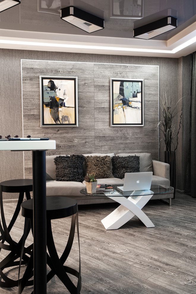 Cette image montre un grand salon design ouvert avec un sol en bois brun, un mur gris et un sol gris.
