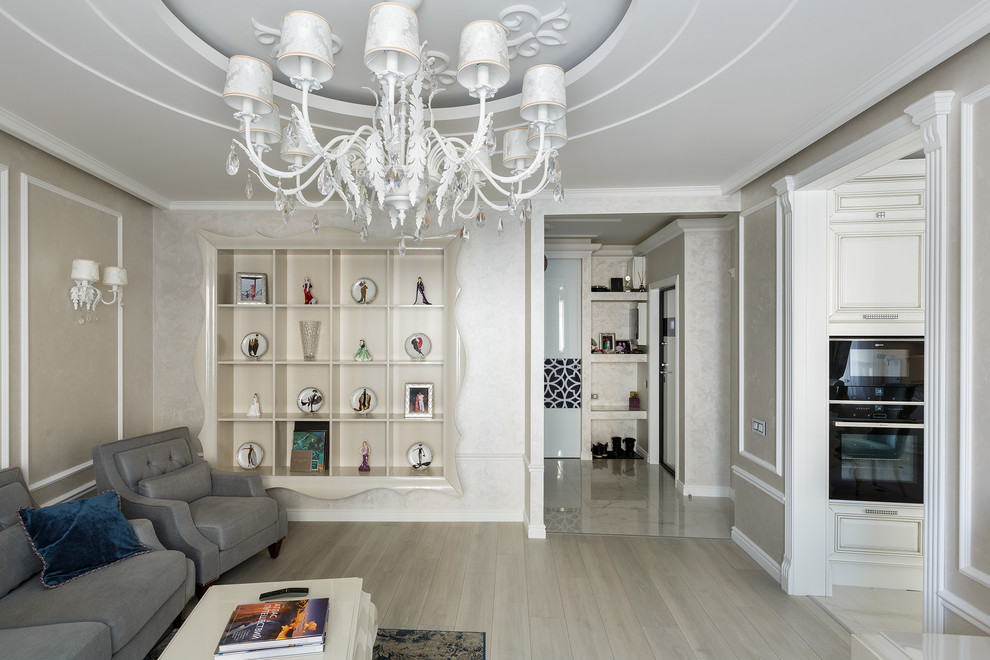 Идея дизайна: изолированная гостиная комната среднего размера в стиле неоклассика (современная классика) с с книжными шкафами и полками, белыми стенами, полом из ламината, телевизором на стене и серым полом без камина