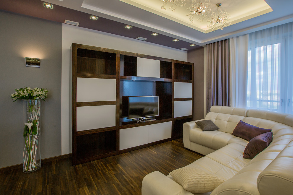 Cette photo montre un grand salon tendance fermé avec un mur gris, un téléviseur indépendant et un sol marron.