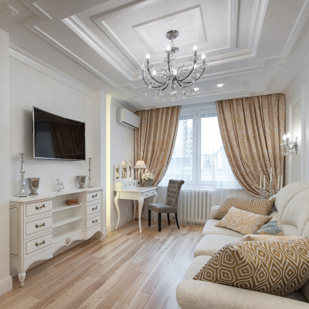 Ejemplo de salón cerrado tradicional de tamaño medio con paredes blancas, suelo de madera clara, televisor colgado en la pared y suelo beige