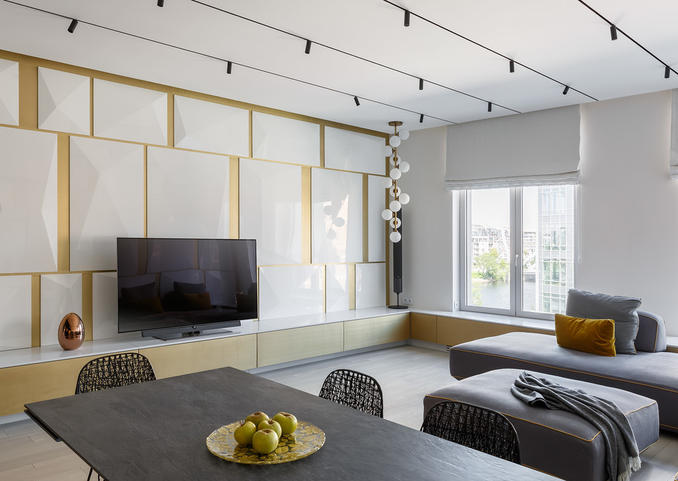На фото: гостиная комната в современном стиле с белыми стенами, светлым паркетным полом и отдельно стоящим телевизором с