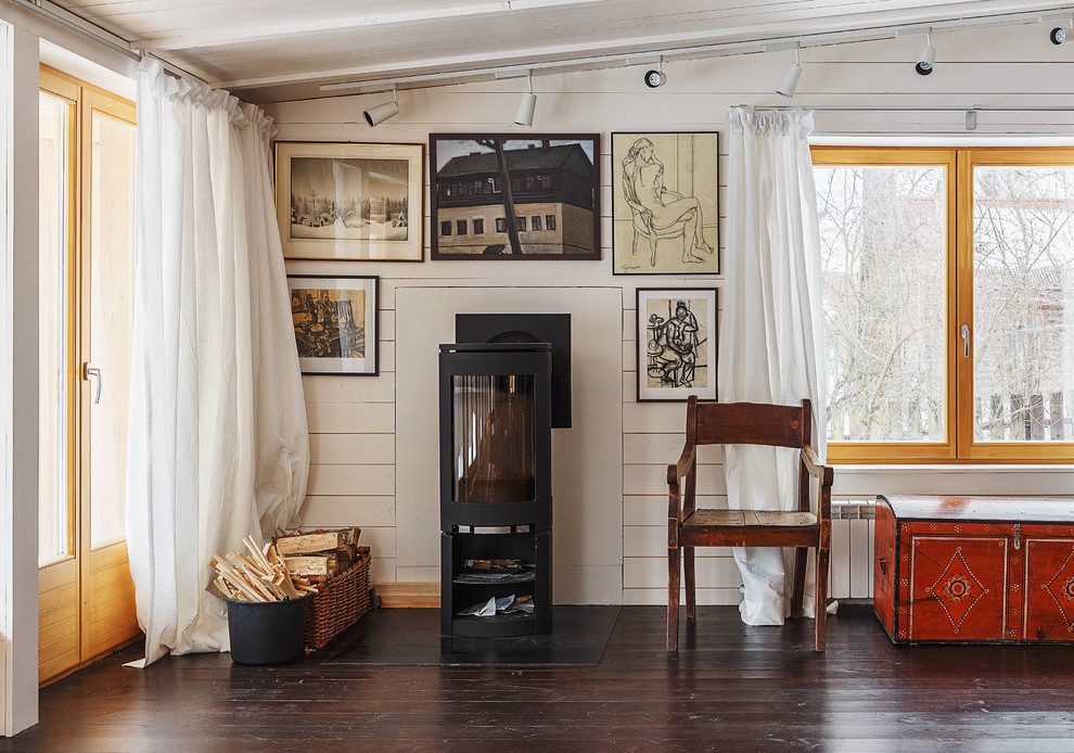 Стильный дизайн: открытая гостиная комната среднего размера в современном стиле с печью-буржуйкой, белыми стенами, деревянным полом и фасадом камина из металла - последний тренд