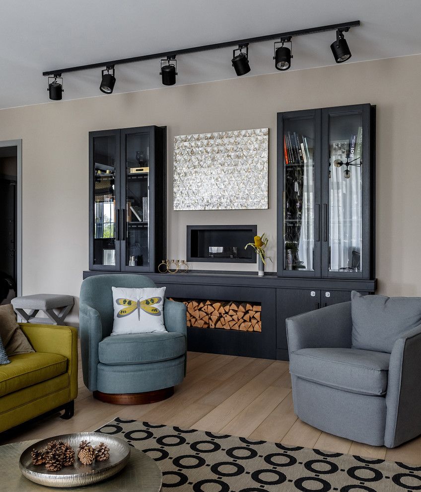 Imagen de salón para visitas abierto actual con paredes beige, suelo de madera clara y televisor colgado en la pared