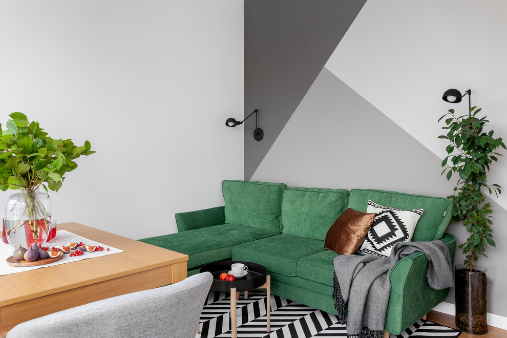 Immagine di un soggiorno nordico con pareti grigie, pavimento in legno massello medio e nessuna TV