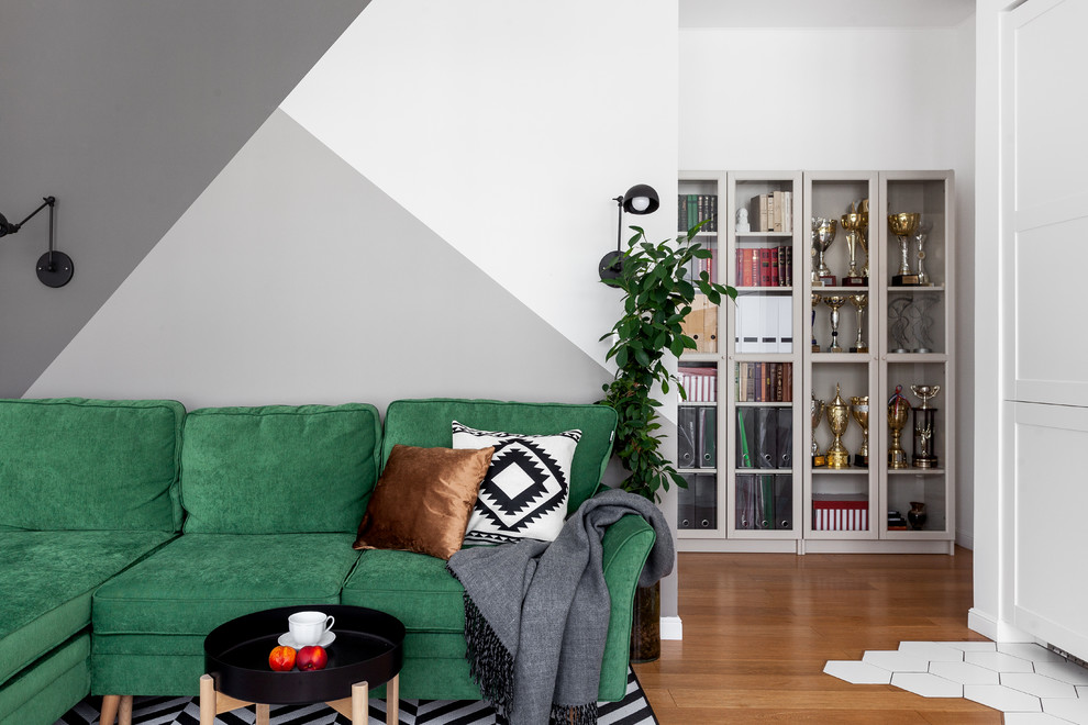 Cette image montre un salon nordique avec un mur gris, un sol en bois brun et aucun téléviseur.
