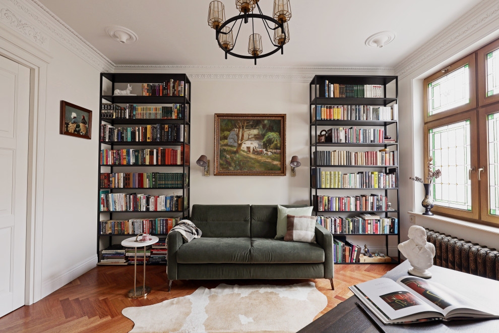 Diseño de biblioteca en casa contemporánea con paredes blancas y suelo de madera en tonos medios