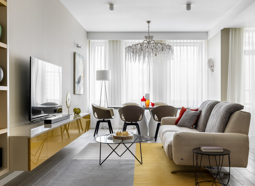 Свежая идея для дизайна: гостиная комната:: освещение в современном стиле с серыми стенами, светлым паркетным полом, отдельно стоящим телевизором и серым полом - отличное фото интерьера