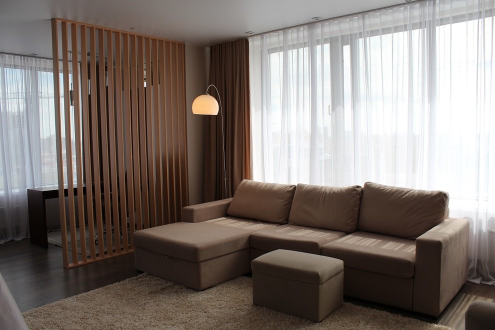 Exemple d'un salon tendance de taille moyenne et ouvert avec un mur beige, sol en stratifié, un téléviseur fixé au mur et un sol marron.