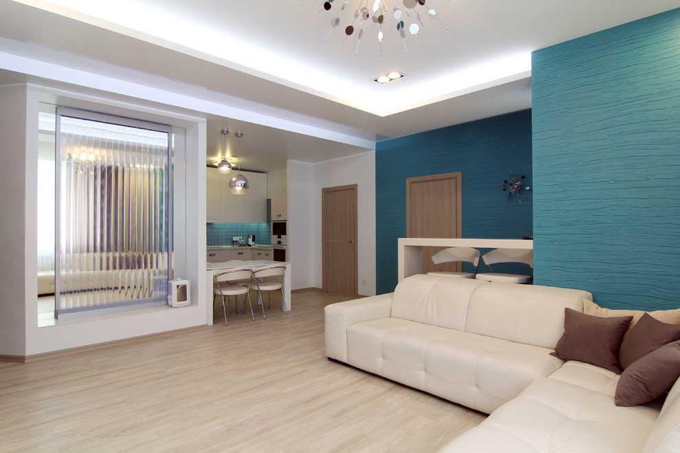 Ejemplo de salón abierto actual de tamaño medio con paredes azules y suelo de madera clara