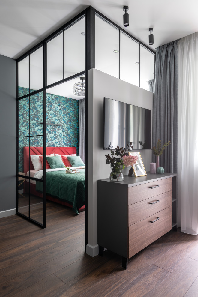Idée de décoration pour un salon design de taille moyenne et ouvert avec un mur gris, sol en stratifié, un téléviseur fixé au mur et un sol marron.