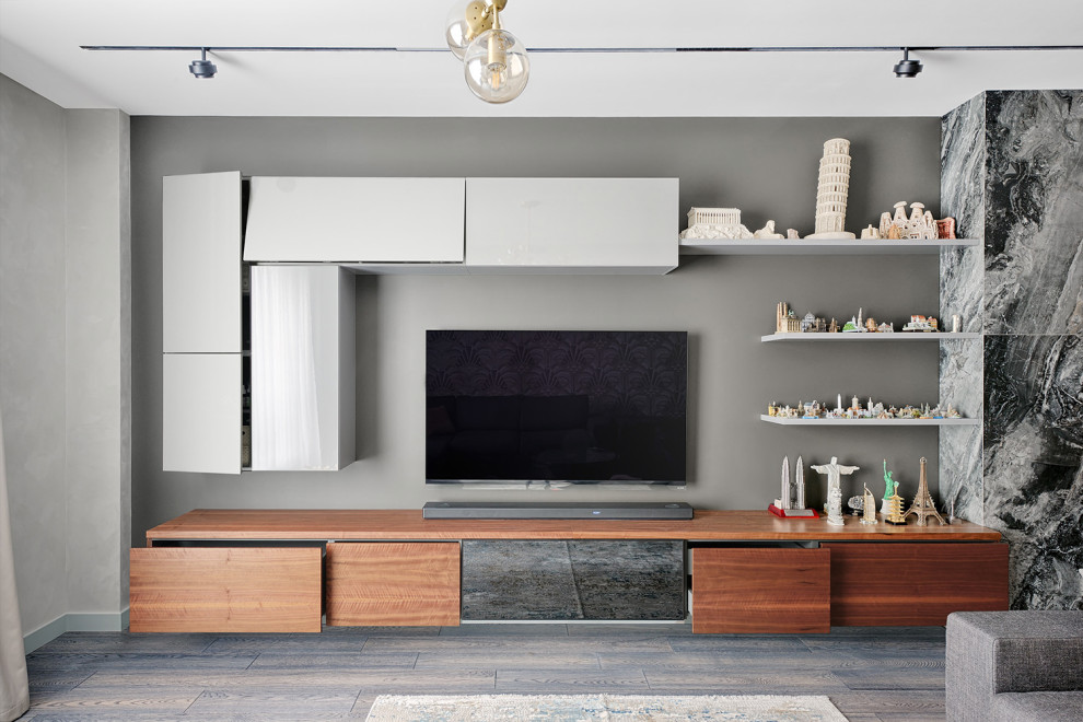 Immagine di un soggiorno minimal aperto con pareti grigie, parquet scuro, TV a parete e pavimento marrone