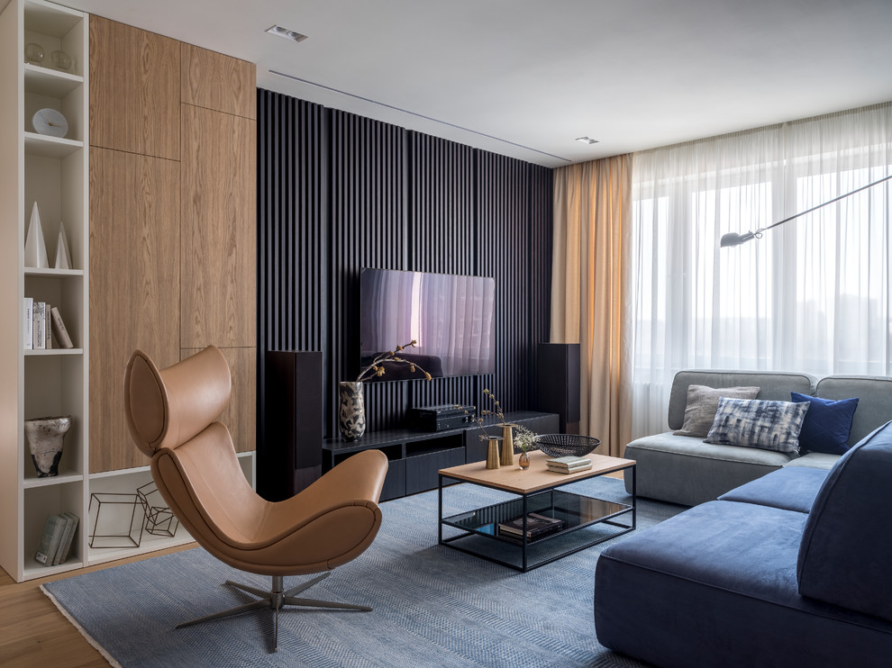 Esempio di un soggiorno design con pavimento in legno massello medio, nessun camino, TV a parete e pavimento beige