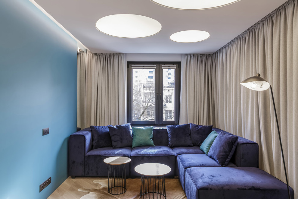 Modelo de salón actual con paredes azules, suelo de madera en tonos medios y suelo marrón