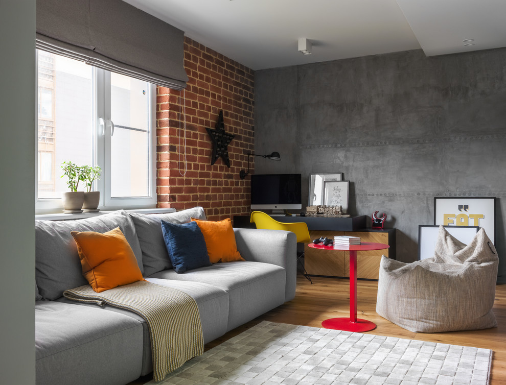 Ejemplo de sala de estar abierta urbana con paredes grises y suelo de madera en tonos medios