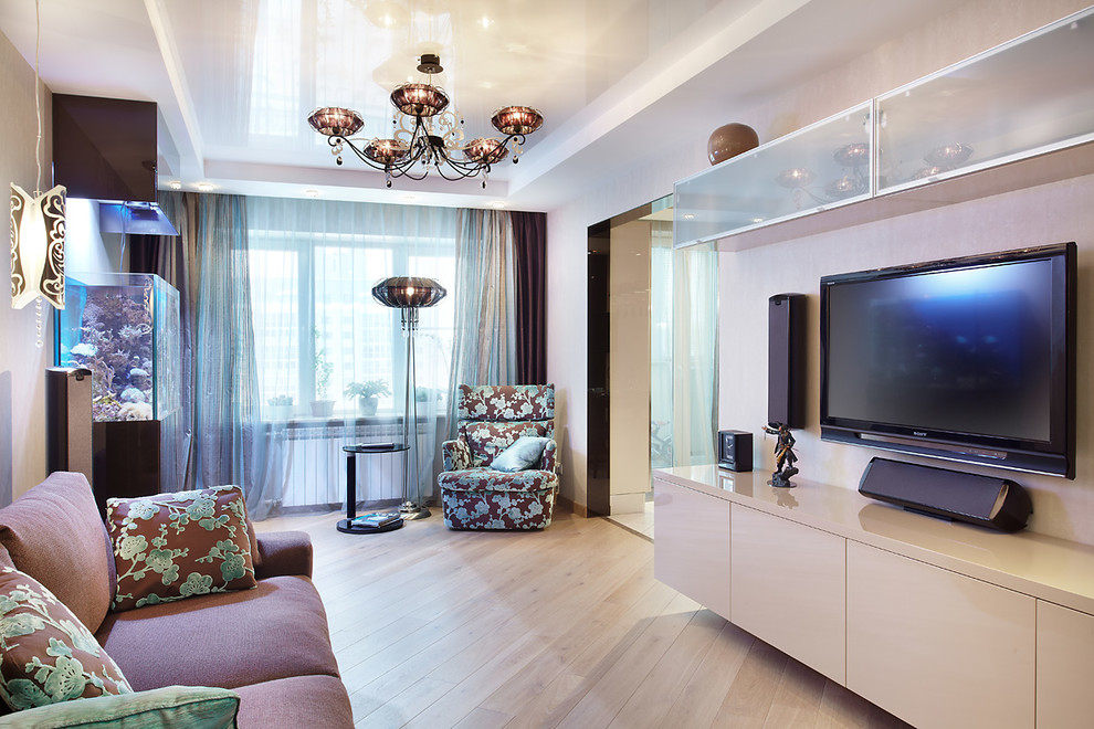 Ejemplo de salón para visitas abierto actual de tamaño medio con paredes beige, suelo de madera clara, televisor colgado en la pared y suelo beige