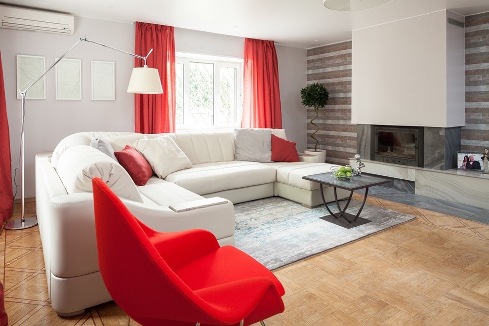 Свежая идея для дизайна: объединенная гостиная комната в современном стиле с серыми стенами, светлым паркетным полом, фасадом камина из штукатурки, зоной отдыха и акцентной стеной - отличное фото интерьера