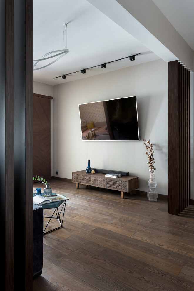 Свежая идея для дизайна: большая открытая гостиная комната в современном стиле с бежевыми стенами, паркетным полом среднего тона, телевизором на стене и коричневым полом - отличное фото интерьера