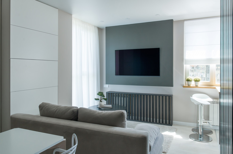 Стильный дизайн: маленькая парадная гостиная комната в современном стиле с полом из ламината, белым полом, серыми стенами и телевизором на стене для на участке и в саду - последний тренд
