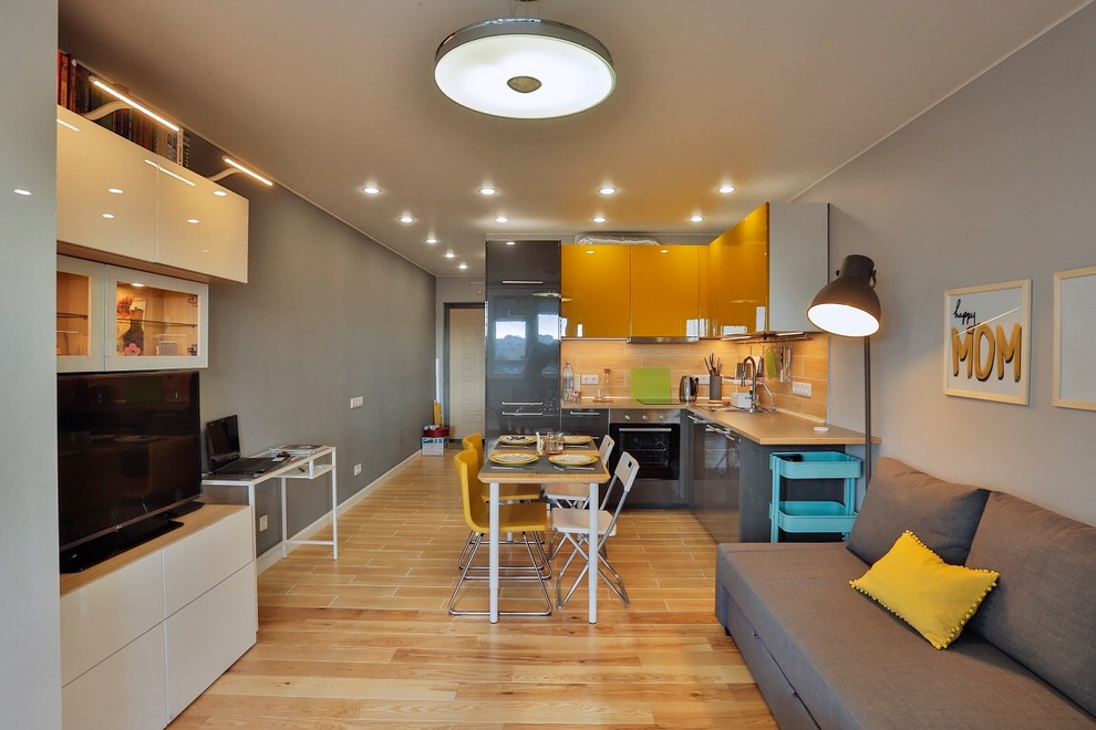 Cette photo montre un petit salon tendance ouvert avec un mur gris, un sol en bois brun, un téléviseur indépendant et un sol marron.