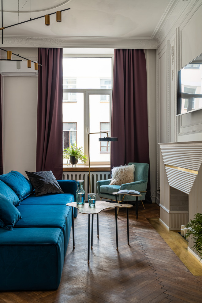 На фото: гостиная комната среднего размера в стиле неоклассика (современная классика) с серыми стенами, паркетным полом среднего тона, стандартным камином, телевизором на стене, коричневым полом и панелями на стенах