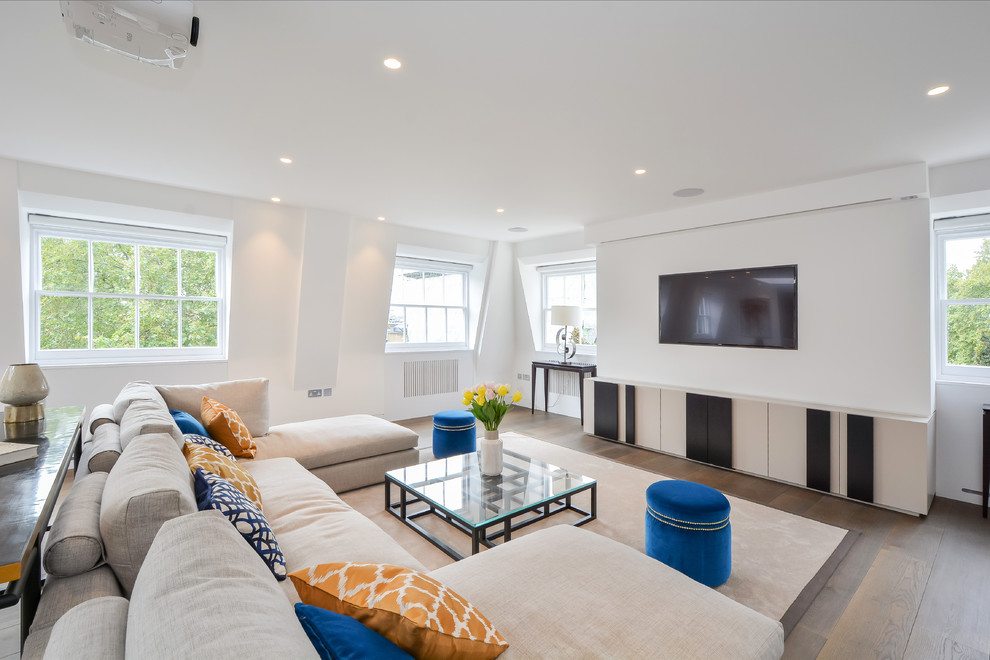 Foto di un soggiorno tradizionale di medie dimensioni e chiuso con pareti bianche, pavimento in legno massello medio, TV a parete e pavimento marrone