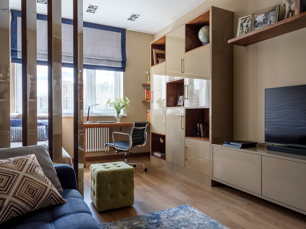 Example of a trendy medium tone wood floor and brown floor living room design in Moscow with beige walls and a tv stand