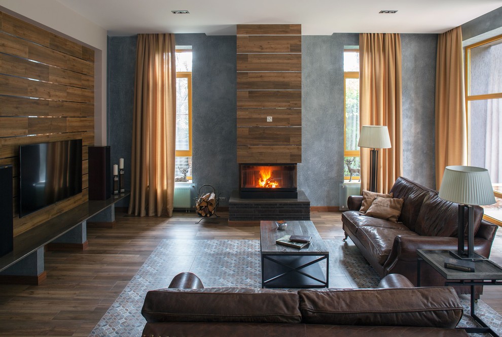 Large contemporary open plan living room in Moscow with grey walls, porcelain flooring, a tiled fireplace surround, a wall mounted tv, a standard fireplace, brown floors and feature lighting.