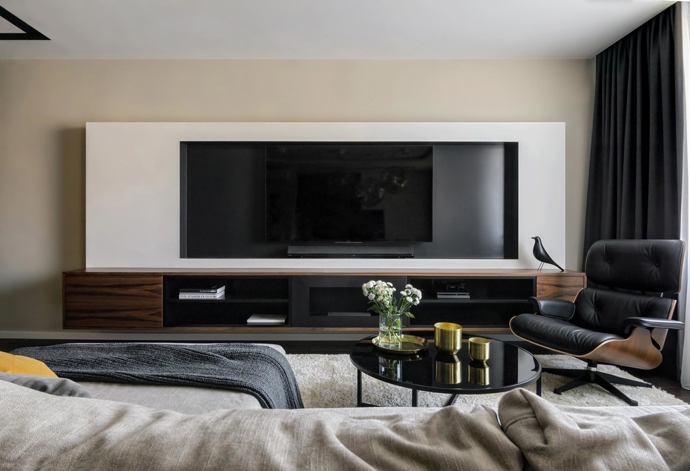 На фото: гостиная комната в современном стиле с телевизором на стене с