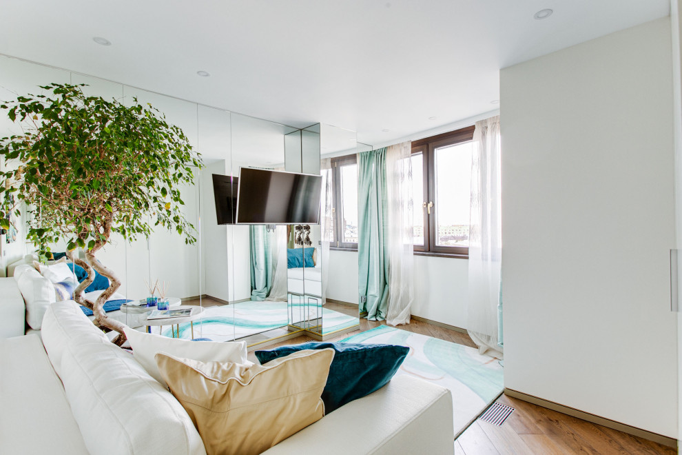 На фото: большая парадная, изолированная гостиная комната в современном стиле с белыми стенами, паркетным полом среднего тона, телевизором на стене и коричневым полом с