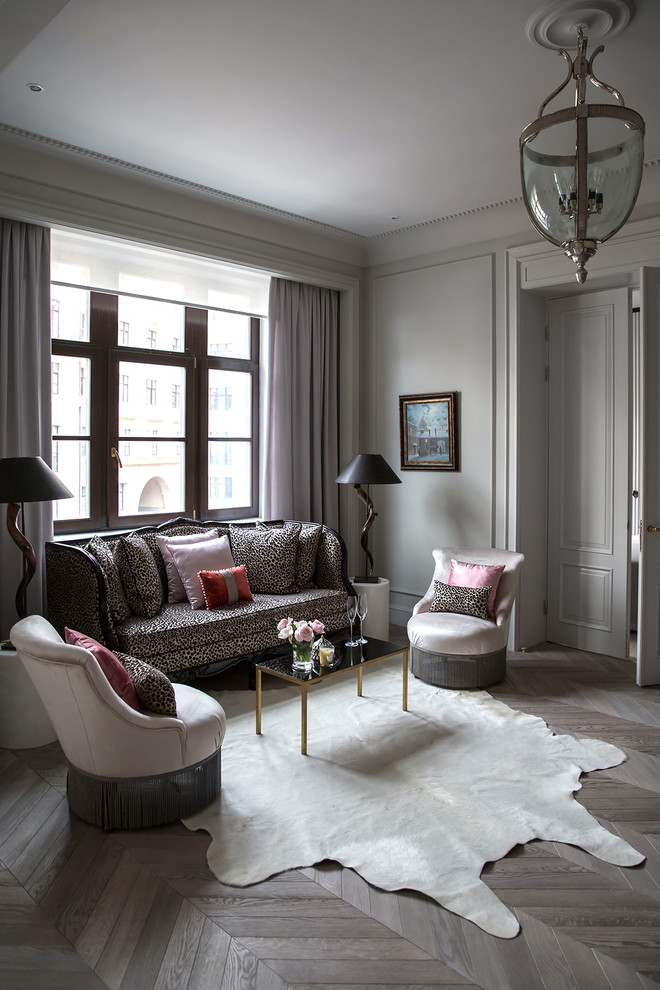 Idée de décoration pour un salon design avec une salle de réception, un mur blanc et un sol en bois brun.