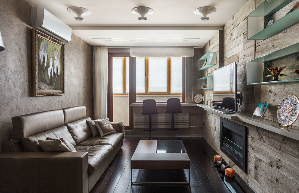 На фото: изолированная гостиная комната в современном стиле с темным паркетным полом, горизонтальным камином, фасадом камина из металла, коричневым полом, серыми стенами и отдельно стоящим телевизором с