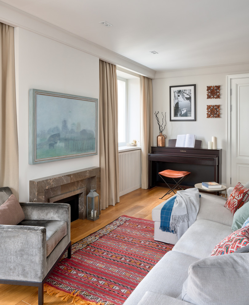 На фото: гостиная комната в стиле неоклассика (современная классика) с белыми стенами, паркетным полом среднего тона, стандартным камином и коричневым полом