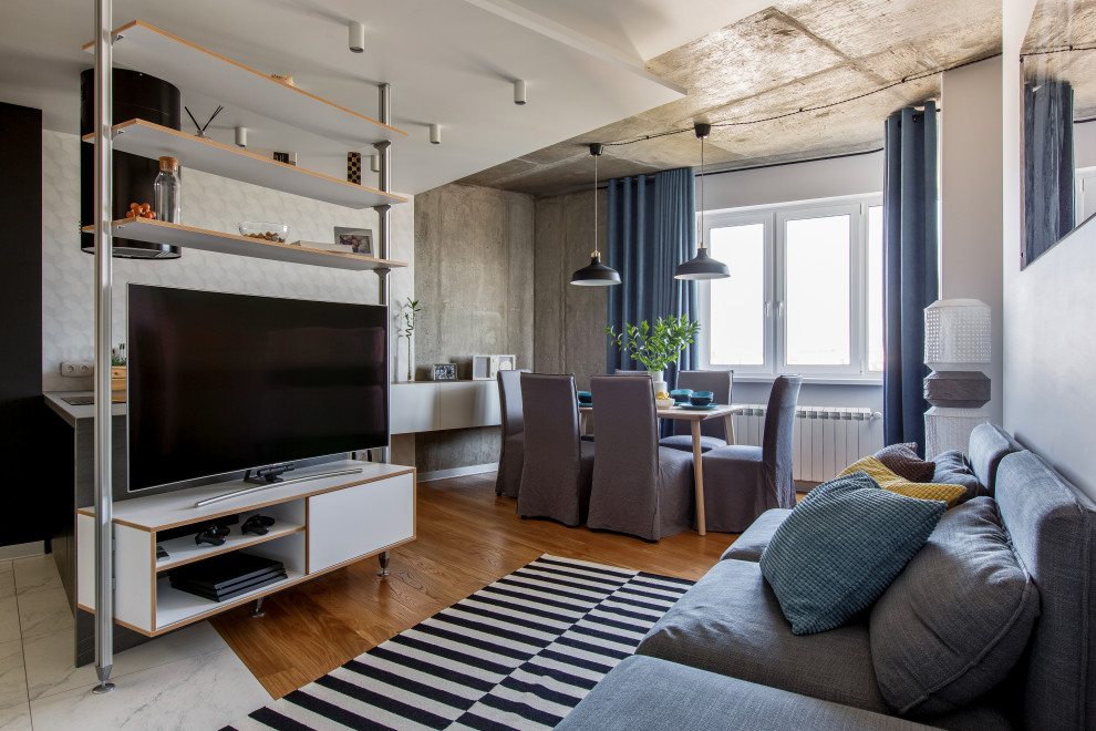 Exempel på ett modernt allrum med öppen planlösning, med grå väggar, mellanmörkt trägolv, en fristående TV och brunt golv