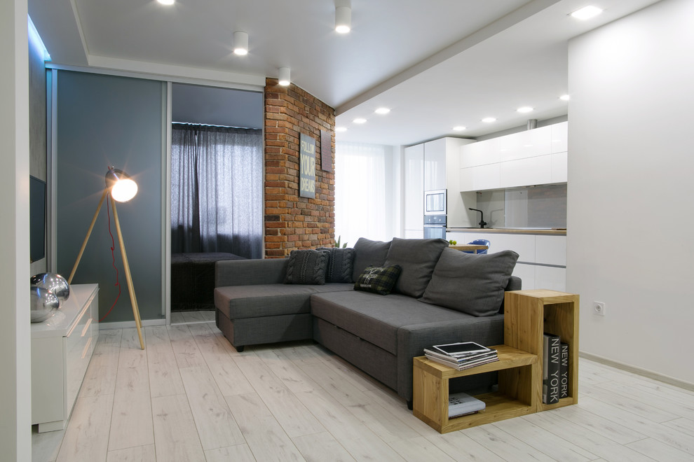Esempio di un soggiorno design aperto e di medie dimensioni con sala formale, pareti bianche, parquet chiaro, TV a parete e pavimento bianco
