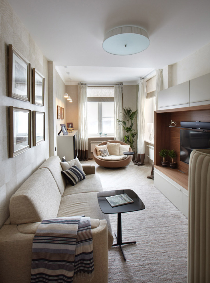 Immagine di un soggiorno design chiuso con TV a parete, sala formale, pareti beige e moquette