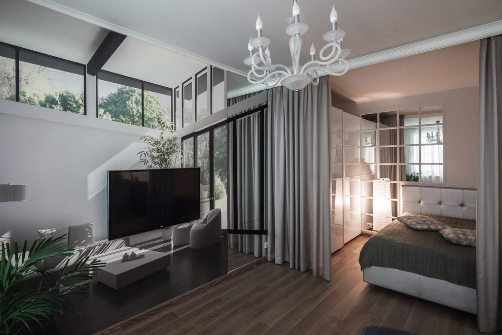 Immagine di un piccolo soggiorno contemporaneo aperto con pareti beige e pavimento in legno massello medio