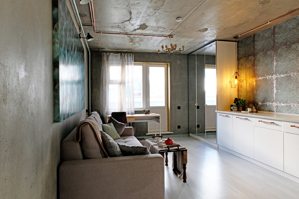 Inredning av ett industriellt vardagsrum, med gröna väggar, laminatgolv och vitt golv