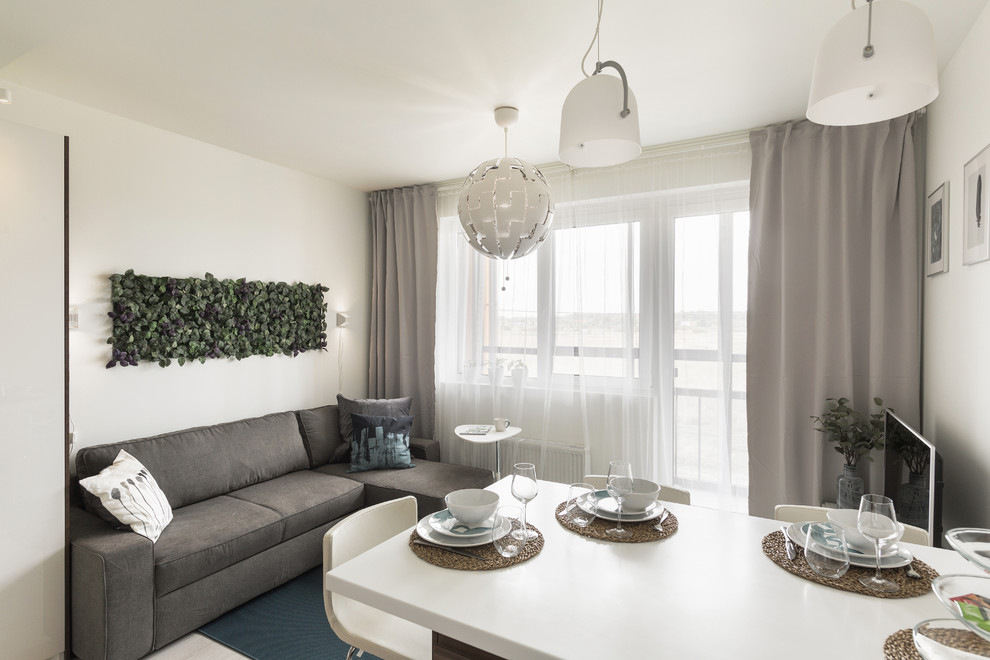 Mittelgroßes, Offenes Skandinavisches Wohnzimmer mit weißer Wandfarbe, Laminat und grauem Boden in Sankt Petersburg