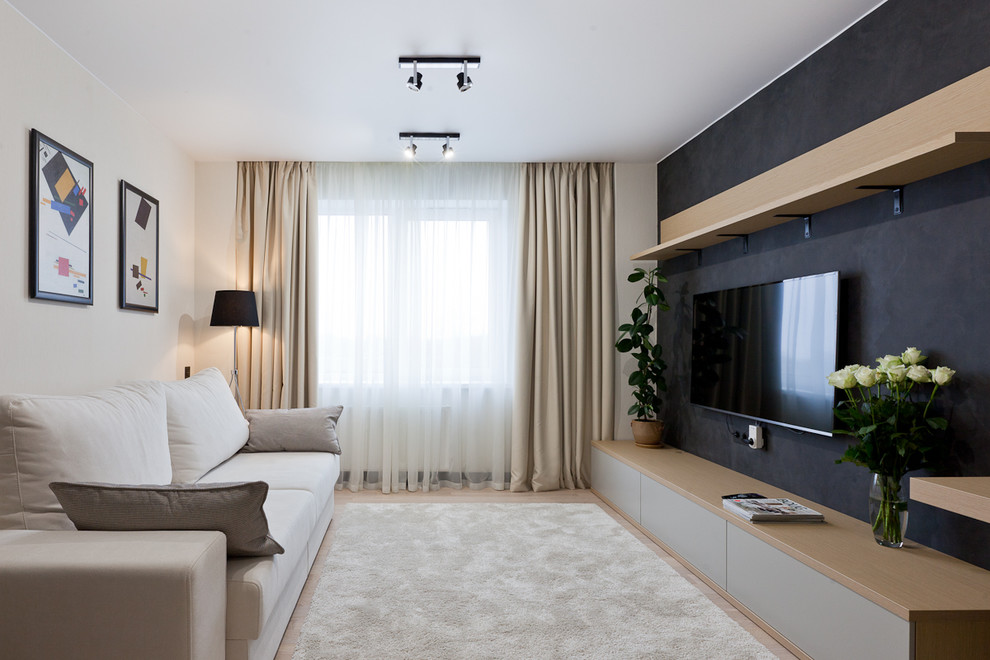 Идея дизайна: изолированная гостиная комната среднего размера в современном стиле с черными стенами, полом из ламината и телевизором на стене