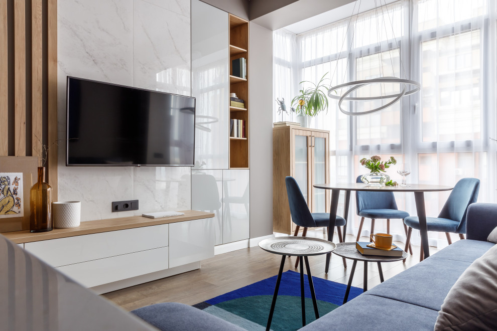Свежая идея для дизайна: парадная, открытая, объединенная гостиная комната в современном стиле с серыми стенами, паркетным полом среднего тона, телевизором на стене и коричневым полом - отличное фото интерьера