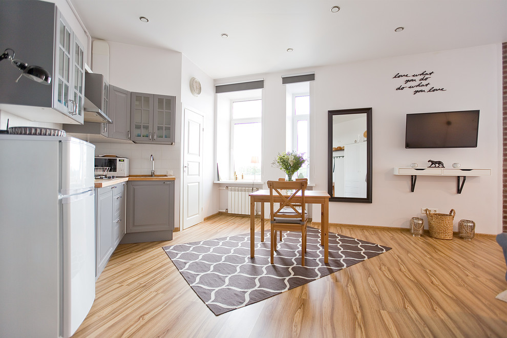 Idee per un piccolo soggiorno contemporaneo aperto con pareti bianche, pavimento in laminato, TV a parete e pavimento giallo
