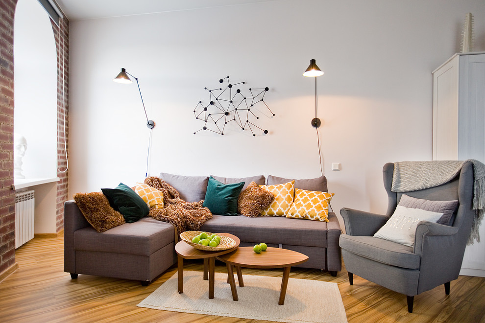 На фото: маленькая открытая гостиная комната в современном стиле с белыми стенами, полом из ламината, телевизором на стене и желтым полом для на участке и в саду с