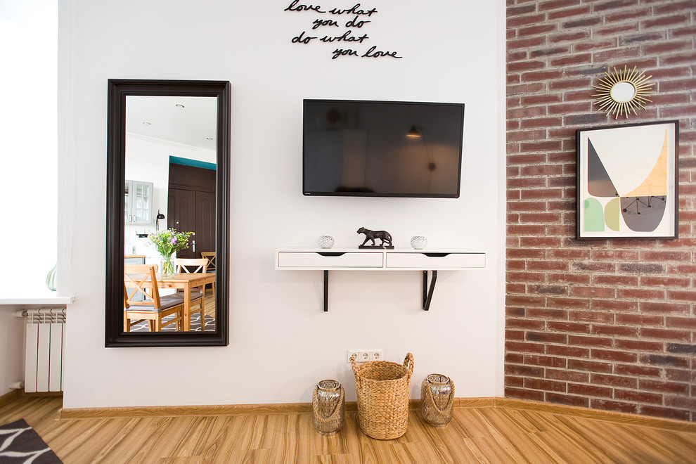 Idee per un piccolo soggiorno design aperto con pareti bianche, pavimento in laminato, TV a parete e pavimento giallo